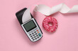 © splitov27 - Payment terminal and donut on a pink background. Top view