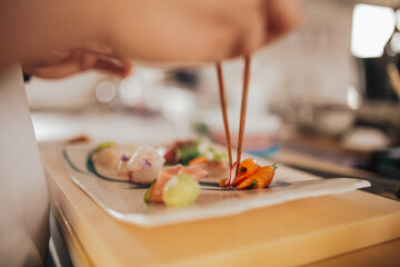 Close up shot of a professional sushi chef preparing sashimi in a restaurant. Traditional Japanese omakase style. Concept of hospitality.