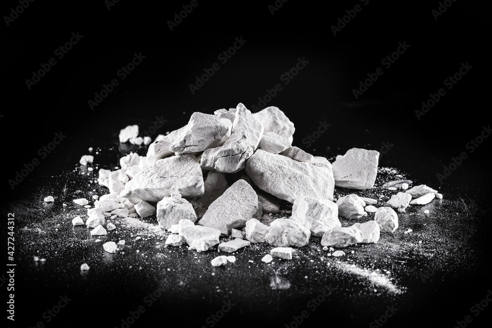 Calcium and Magnesium stones, black background. Called virgin lime or quicklime - obrazy, fototapety, plakaty 