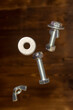 falling screws, washer and retaining nut on blurred brown background