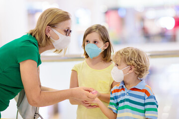 Wall Mural - Mother and child with face mask and hand sanitizer