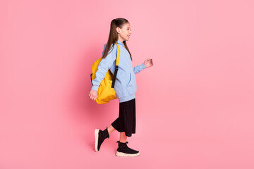 Sticker - Full length body size side profile photo of small schoolgirl with yellow rucksack walking to school isolated pastel pink color background