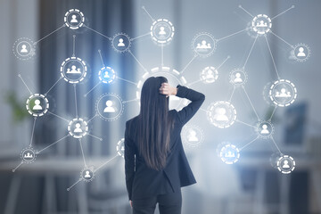 Aufkleber - Puzzled businesswoman looking at the multiple application hologram icons with coworking space in the background. Social media and communication concept