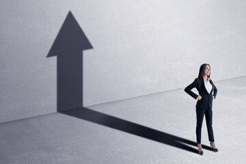 Wall Mural - Success concept with happy businesswoman and black growing arrow as her shadow on concrete wall background