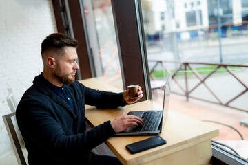 Sticker - Attractive handsome businessman working on distance in a cafe. Young male have a coffee break after work.