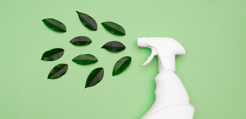 eco style cleaning concept. white bottle spray for daily spring cleaning sprays green leaves on a gr