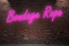 Neon Bondage Rope Lettering On Brick Wall At Night