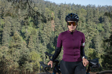 Ciclista Con Casco Y Gafas De Sol, Posando Con Su Bicicleta Al Lado De La Carretera En Medio Del Bosque