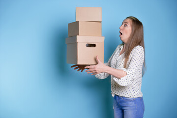 Accept a parcel, happy young woman holding a stack of cardboard boxes,