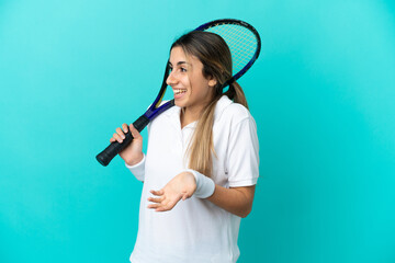 Young woman tennis player isolated on blue background with surprise expression while looking side