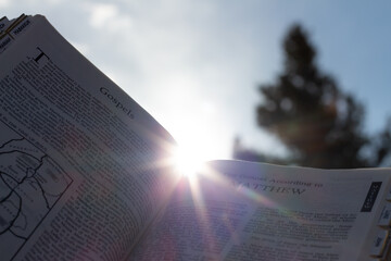 Poster - Open bible with sunlight and sky behind