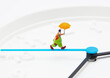 Closeup shot of clown holding umbrella figurine minute clock isolated on white background