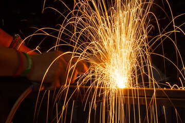 Wall Mural - Iron welding close-up, sparks do not wear gloves. Welding sparks and fumes It can be dangerous to health.