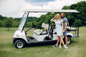 Wall Mural - Beautiful couple playing golf on a golf course