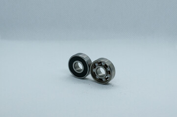 Closeup of two isolated metallic ball bearings on a grey background