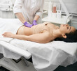© Peakstock - Doctor palpates a young woman's belly in a medical clinic. Physician doing a medical examination for female body for disease prevention