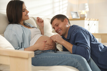 Wall Mural - Young pregnant woman with her husband at home