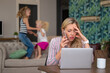 © Kaspars Grinvalds - Woman working at home while kids are playing in background
