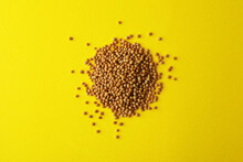 Heap Of Mustard Seeds On Yellow Background, Top View