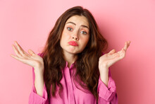 Close Up Portrait Of Clueless Woman Looking Coy And Unaware, Shrugging Shoulders, Know Nothing, Cant Understand, Standing Over Pink Background