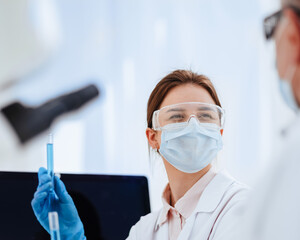 Wall Mural - close up. female scientist looking at liquid in test tubes.