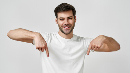 Wall Mural - Young man wearing t-shirt pointing thumbs down