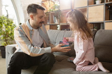 Wall Mural - Happy father and little cute daughter at home. Family time, togehterness, parenting and happy childhood concept. Weekend with sincere emotions.