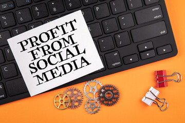 Wall Mural - profit from social media. computer keyboard on orange table