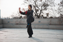 Woman On One Leg With Lifted Hands Doing Tai Chi