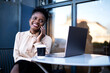 © JustLife - Businesswoman talking to the phone in cafe. Beautiful woman with laptop in coffee shop.