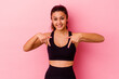 © Asier - Young sport Indian woman isolated on pink background points down with fingers, positive feeling.