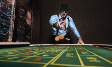 Brutal Athletic Man Dressed In Suit With A Cigar Plays In A Casino                         
