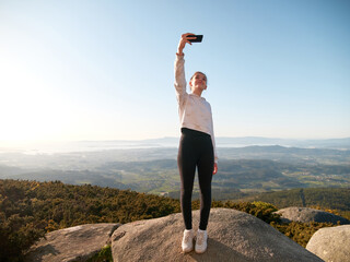 Young girl taking a selfie on the mountain