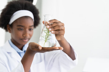 african american girl scientists holding glassware for tests of plants in the classroom. girl learni