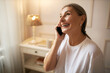© shurkin_son - Cheerful charming senior woman in casual clothing holding mobile, having phone conversation, receiving good news, expressing excitement. Happy gray haired grandmother talking to family using gadget