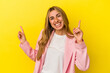 © Asier - Young blonde caucasian woman isolated on yellow background pointing to different copy spaces, choosing one of them, showing with finger.