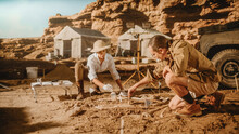 Archaeological Digging Site: Two Great Paleontologists Discovered Fossil Remains Of Prehistoric Dinosaur, Clean It With Brushes. Archeologists Work On Excavation Site, Discover New Species Bones