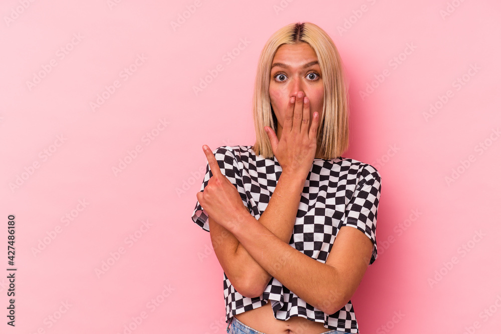 Young venezuelan woman isolated on pink background pointing to the side - obrazy, fototapety, plakaty 