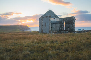 Wall Mural - Old, ancient stone ruins of the remote and isolated Kilmuir Church in the seaside Scottish rural countryside at sunset or sunrise on the Isle of Skye, Scotland.