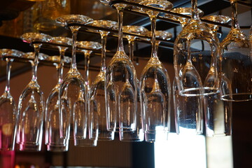 Clean  Champagne Glasses hanging from copper pipe rack in bar - シャンパン グラス 