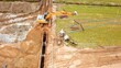 Bagger verlegt Rohre,  Erschließung eines Baugebiets, Tiefbau, Kanalbau, Rohrleitungsbau aus der Vogelperspektive