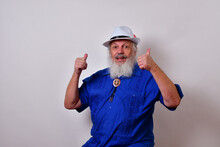 Happy Old Man With A White Fedora Hat, Blue Guayabera Shirt, And Bolo Tie Showing A Double Thumbs Up