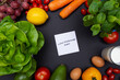 Biała karteczka na czarnym tle z napisem low FODMAP, otoczona warzywami i owocami z miejscem na tekst o diecie, zdrowym odżywianiu, nawykach żywieniowych. Flat lay