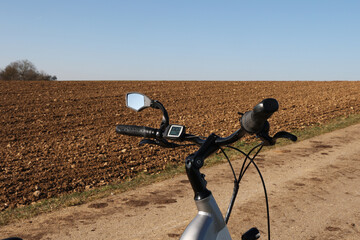 Poster - Bicycle steering wheel on a plowed field background