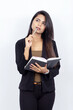 Indian businesswoman on white background holding a pen and an open notebook - thinking and ideating