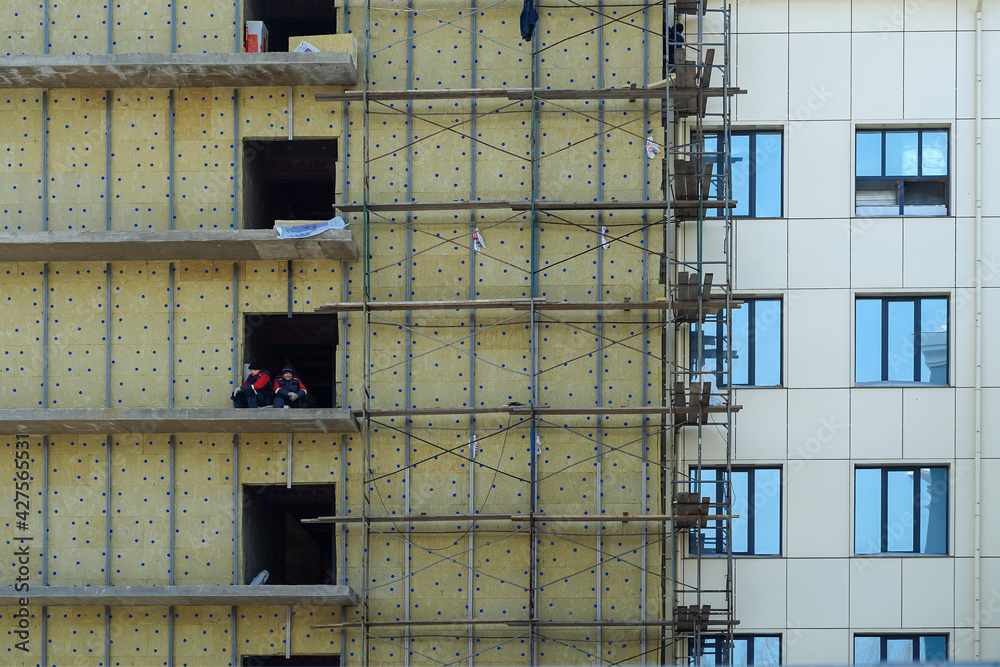 Insulation of apartment building at construction stage. Urban city life ...