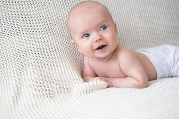 happy little baby boy lying on white plaid. Happy family