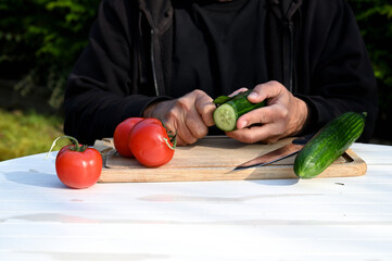 Sticker - Man peeling cucumber on a wooden board