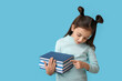 © Pixel-Shot - Cute little girl with books on color background
