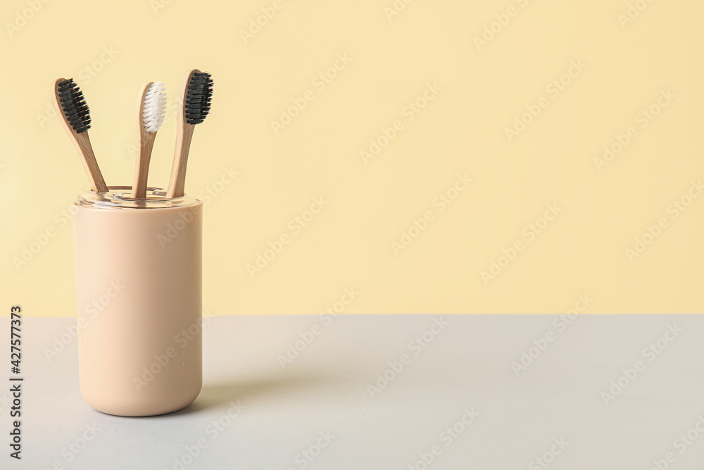 Holder with tooth brushes on light background